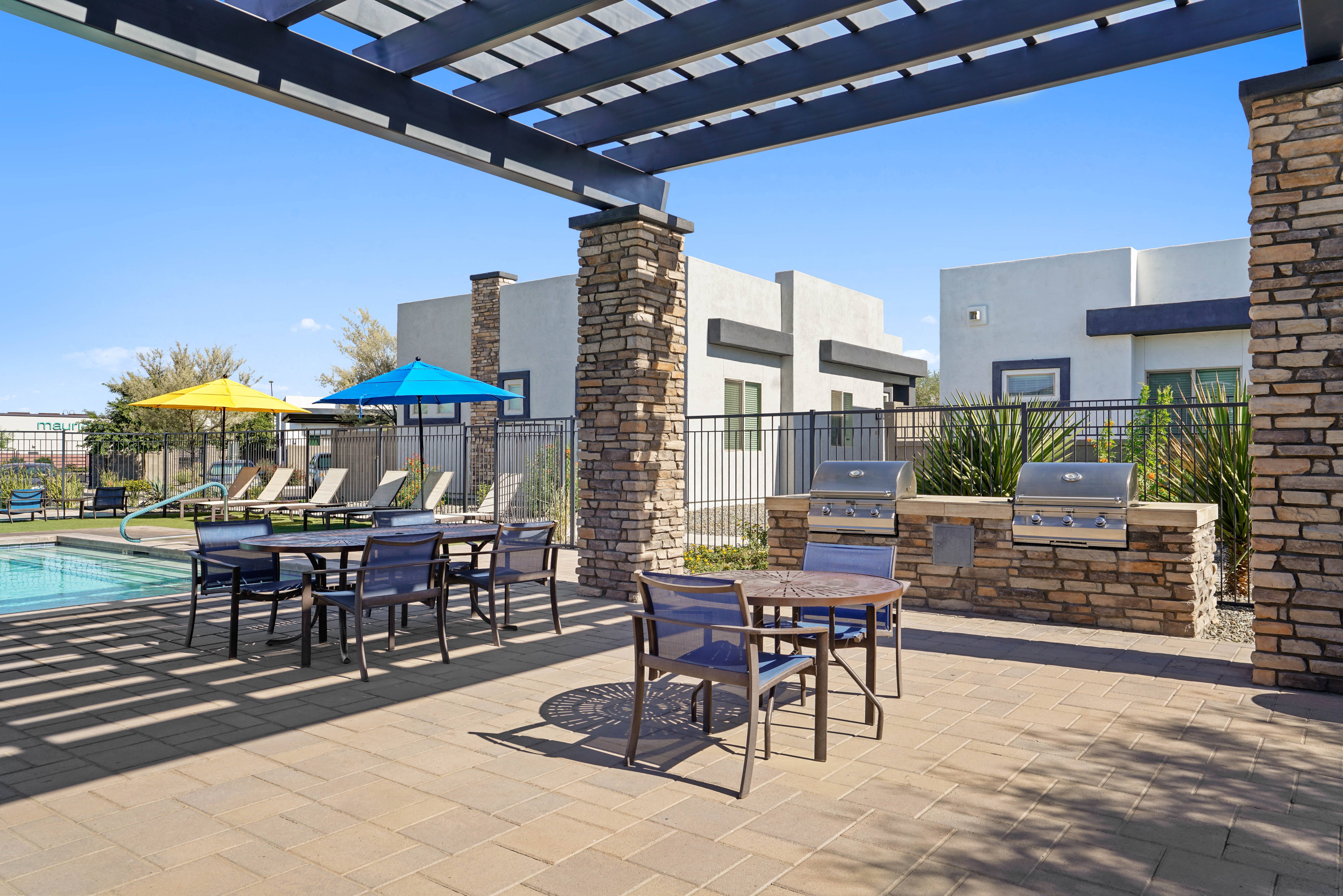 our apartments have a large patio with tables and chairs and a pool at Olive Queen Creek Apartments, Queen Creek